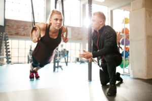 "Personal trainer assisting a client with an at-home workout in downtown Toronto, using minimal equipment for an efficient and effective session."